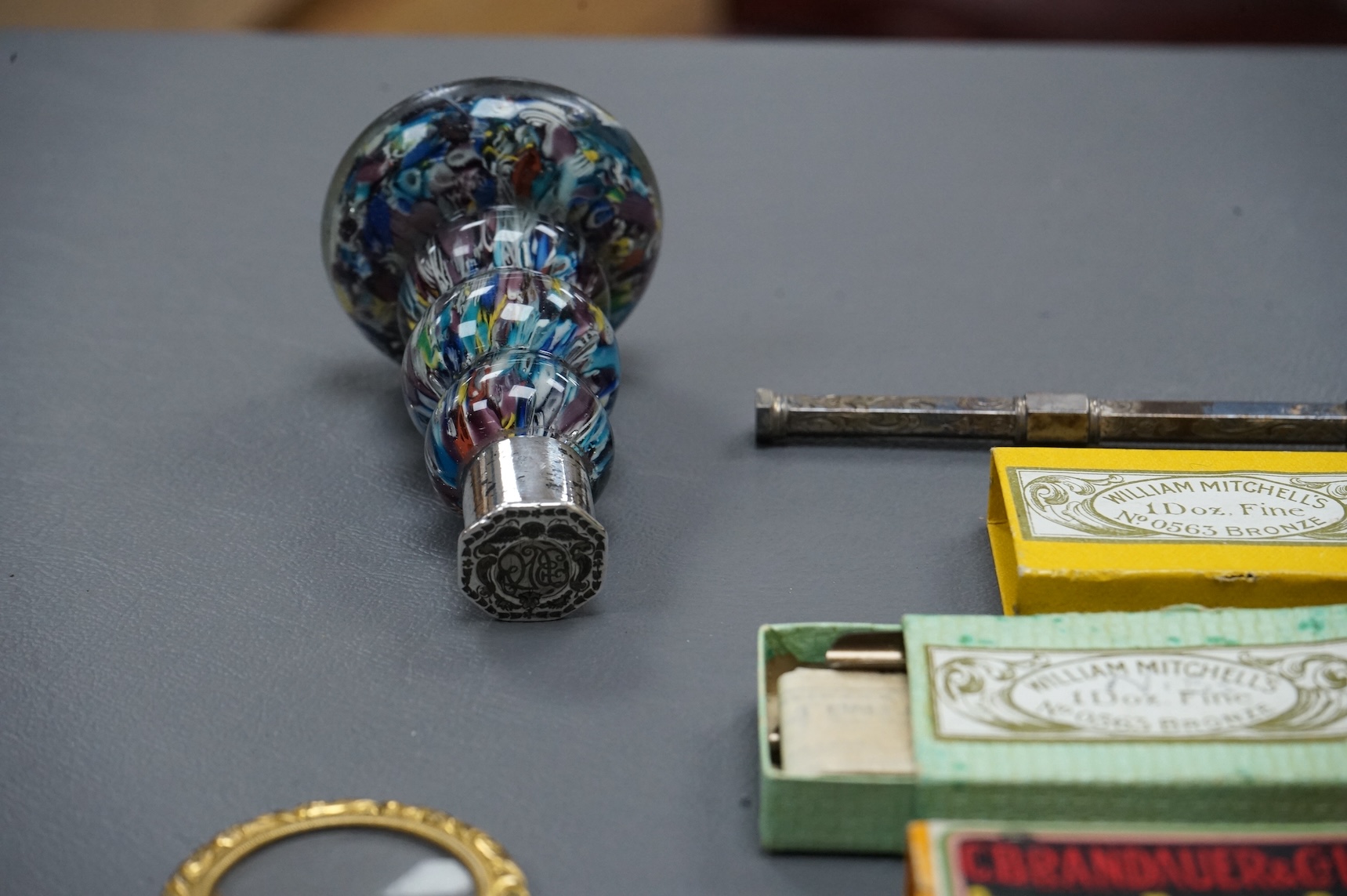 A small collection of objects to include a 17th century? French multi-cane glass seal, miniature white metal mirror and boxed pen nibs, seal 8cm high